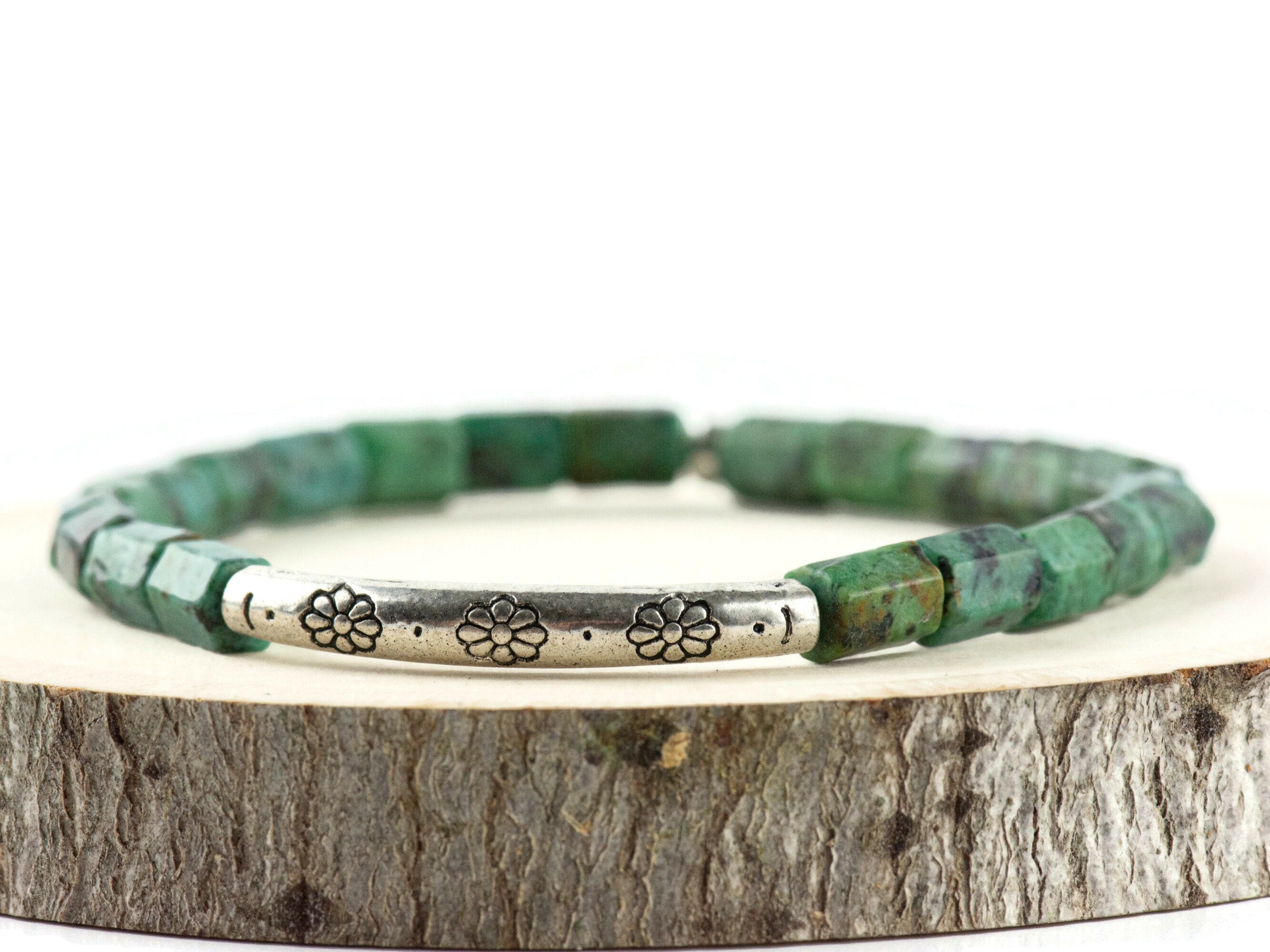 African Turquoise Stretch Bracelet displayed on a wood piece with tree bark edging