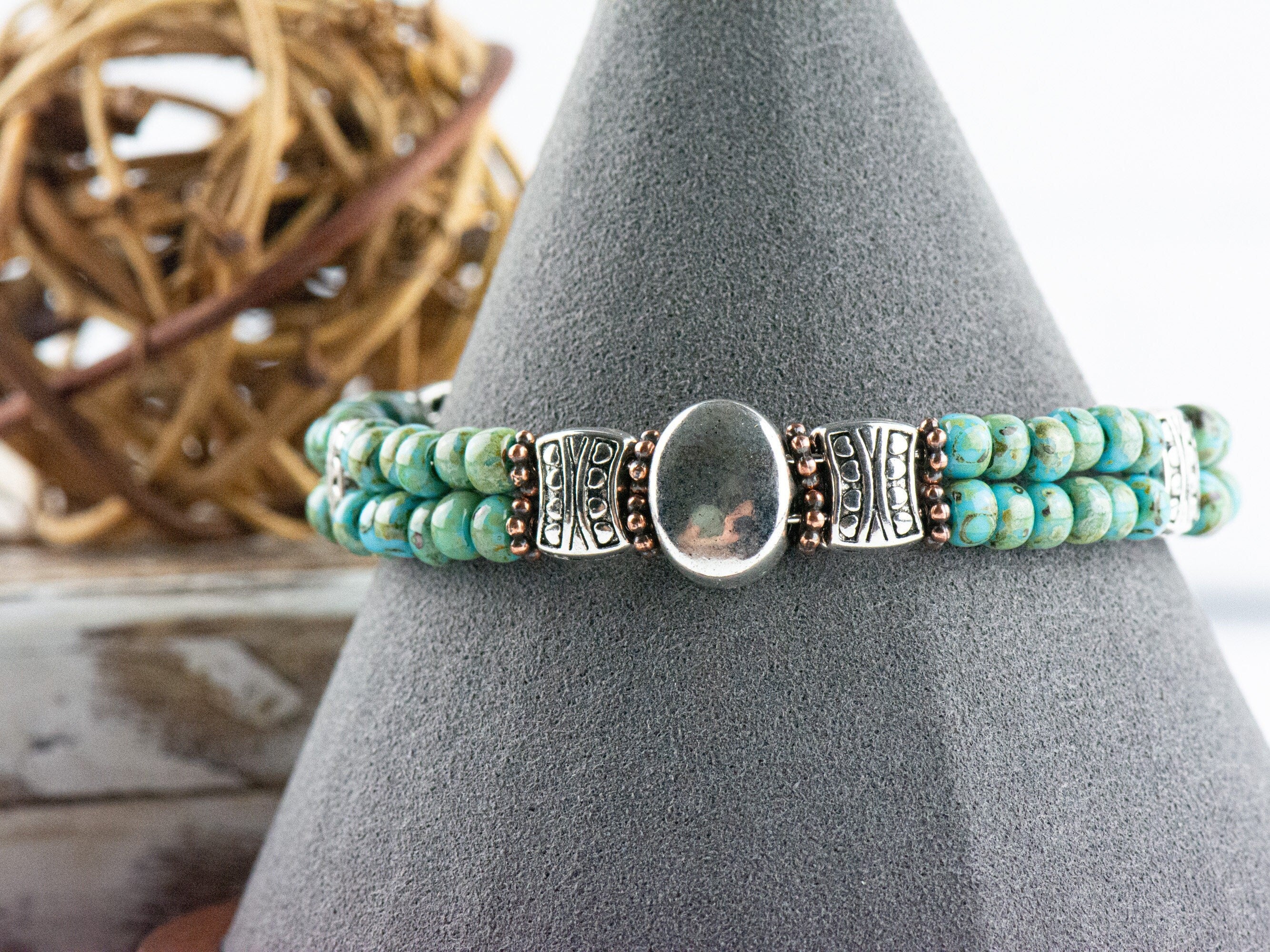 Button and Bows Desert Turquoise Cuff Memory Wire Bracelet displayed on a decorative black bracelet stand.