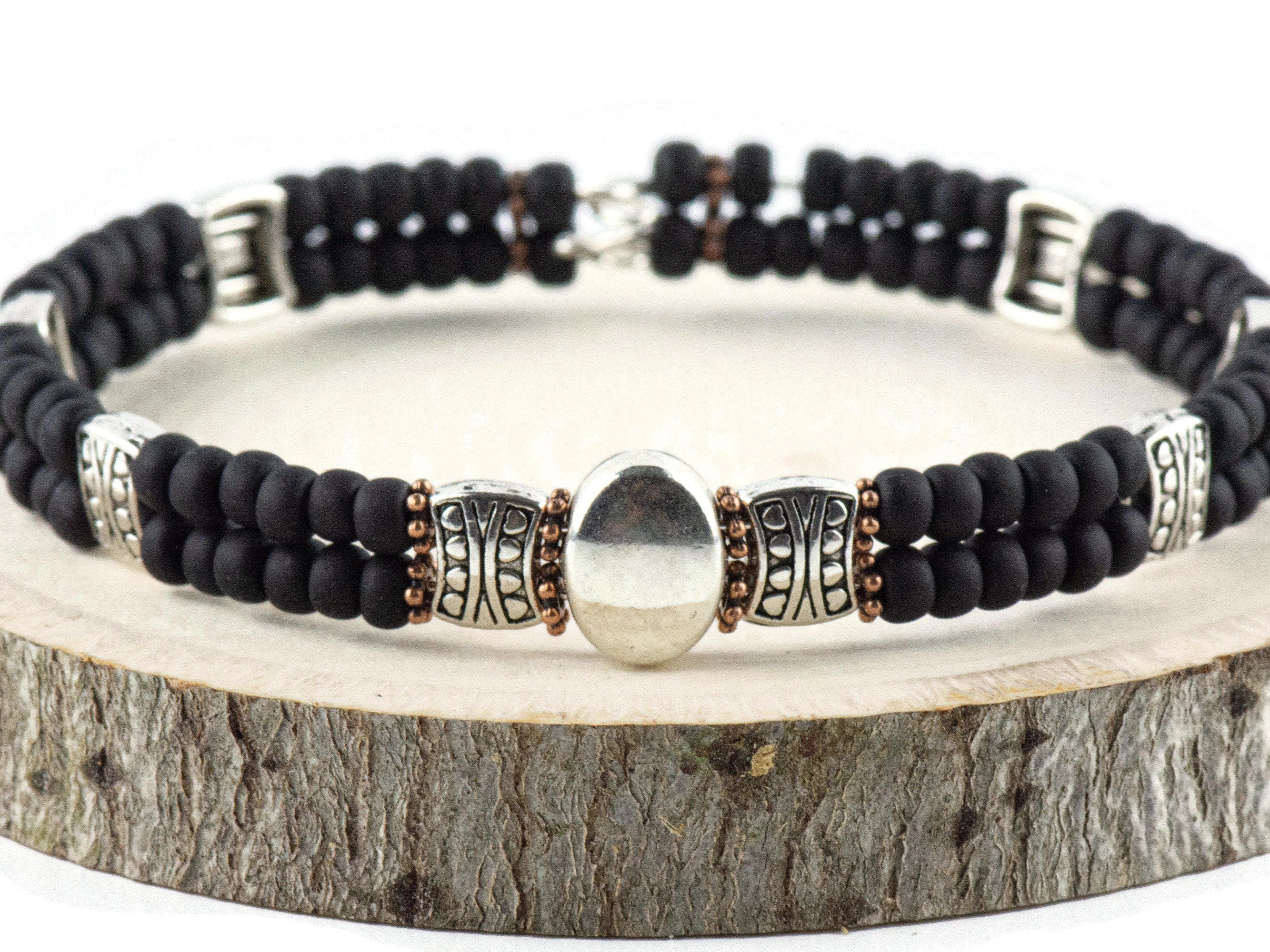 Button and Bows Jet Black Cuff Memory Wire Bracelet on a wood piece with tree bark edging