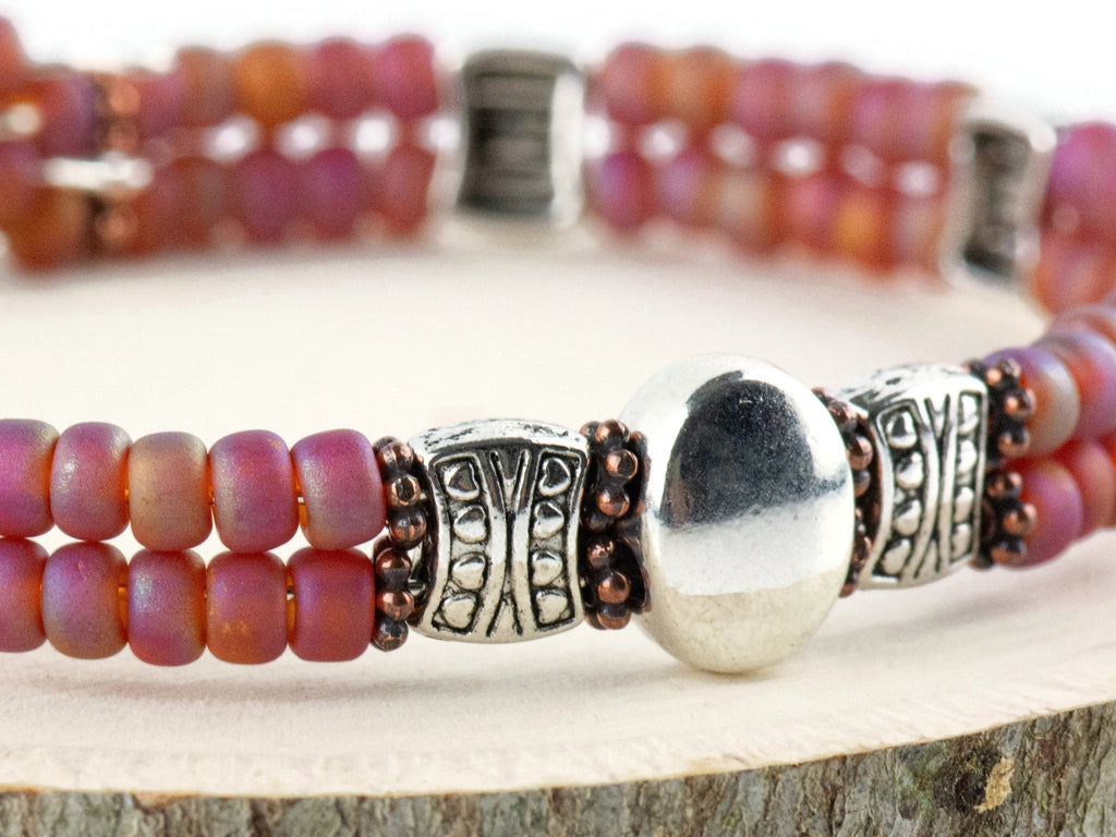 Button and Bows Raspberry Sorbet Cuff Memory Wire Bracelet close up on a wood piece with tree bark edging