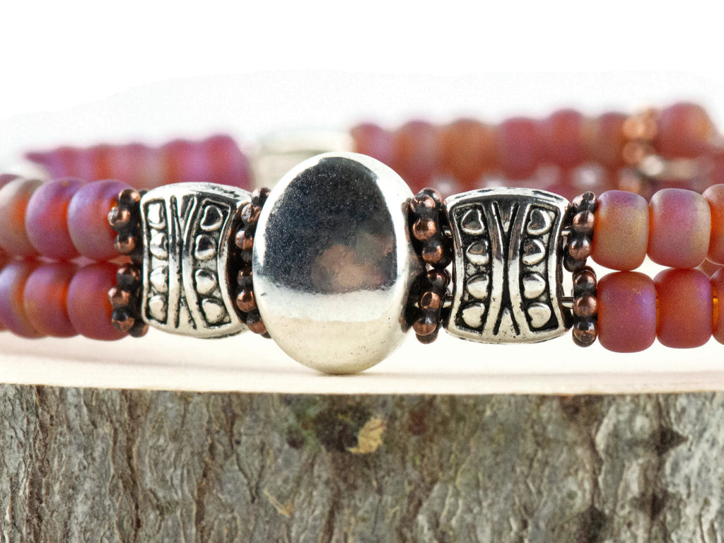 Button and Bows Raspberry Sorbet Cuff Memory Wire Bracelet close up on a wood piece with tree bark edging