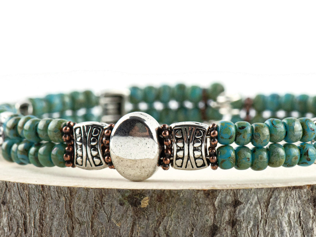 Button and Bows Desert Turquoise Cuff Memory Wire Bracelet close up on a wood piece with tree bark edging