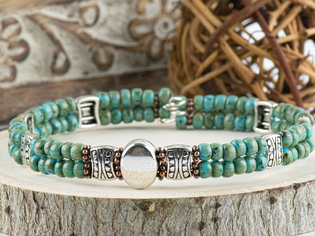 Button and Bows Desert Turquoise Cuff Memory Wire Bracelet close up on a wood piece with tree bark edging