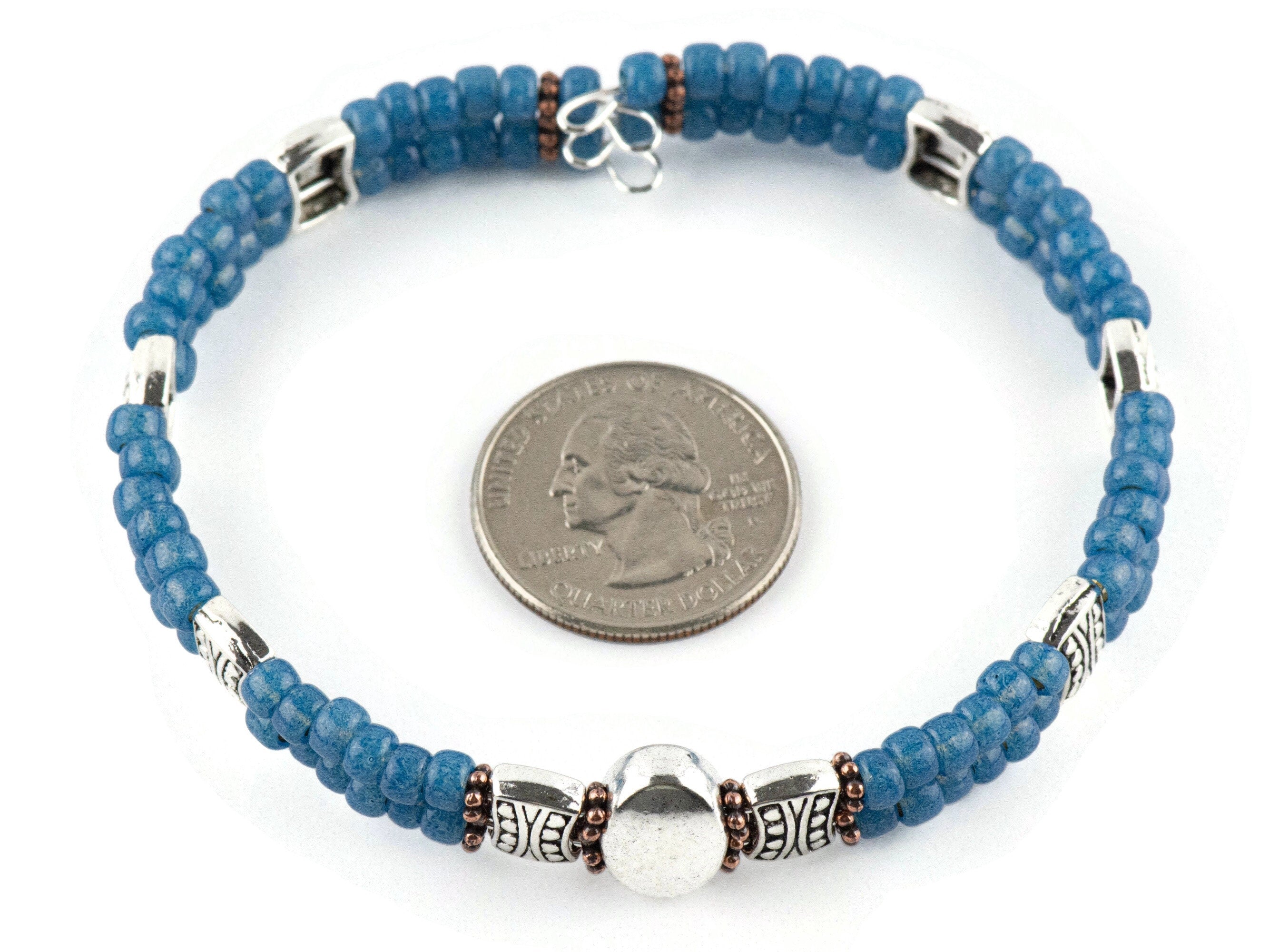 Button and Bows French Blue Cuff Memory Wire Bracelet on a white background. Quarter in center of bracelet is for a size reference.