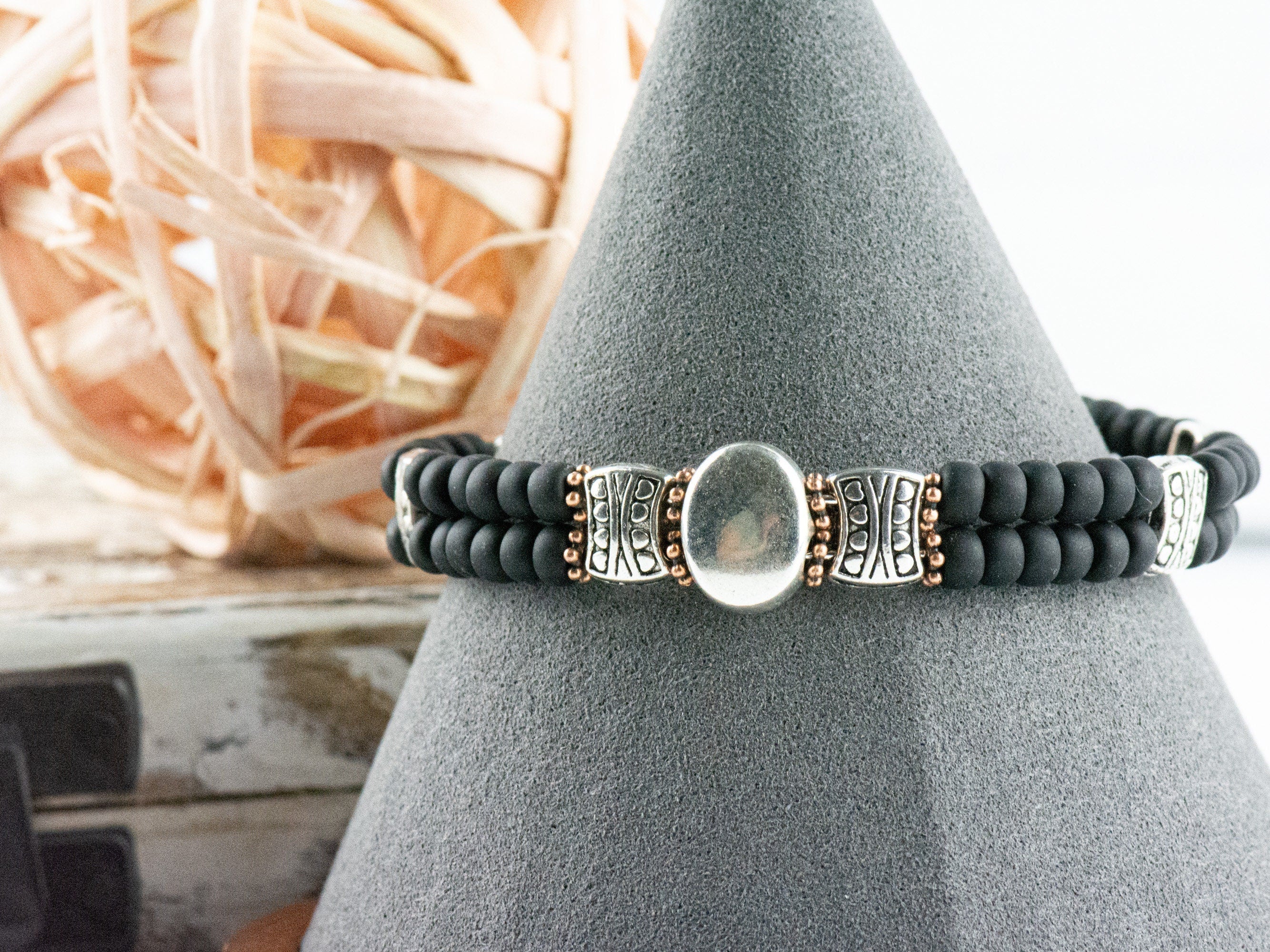 Button and Bows Jet Black Cuff Memory Wire Bracelet on a decorative black bracelet stand.
