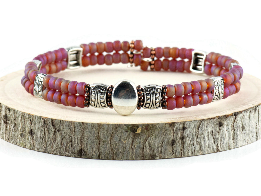 Button and Bows Raspberry Sorbet Cuff Memory Wire Bracelet on a wood piece with tree bark edging