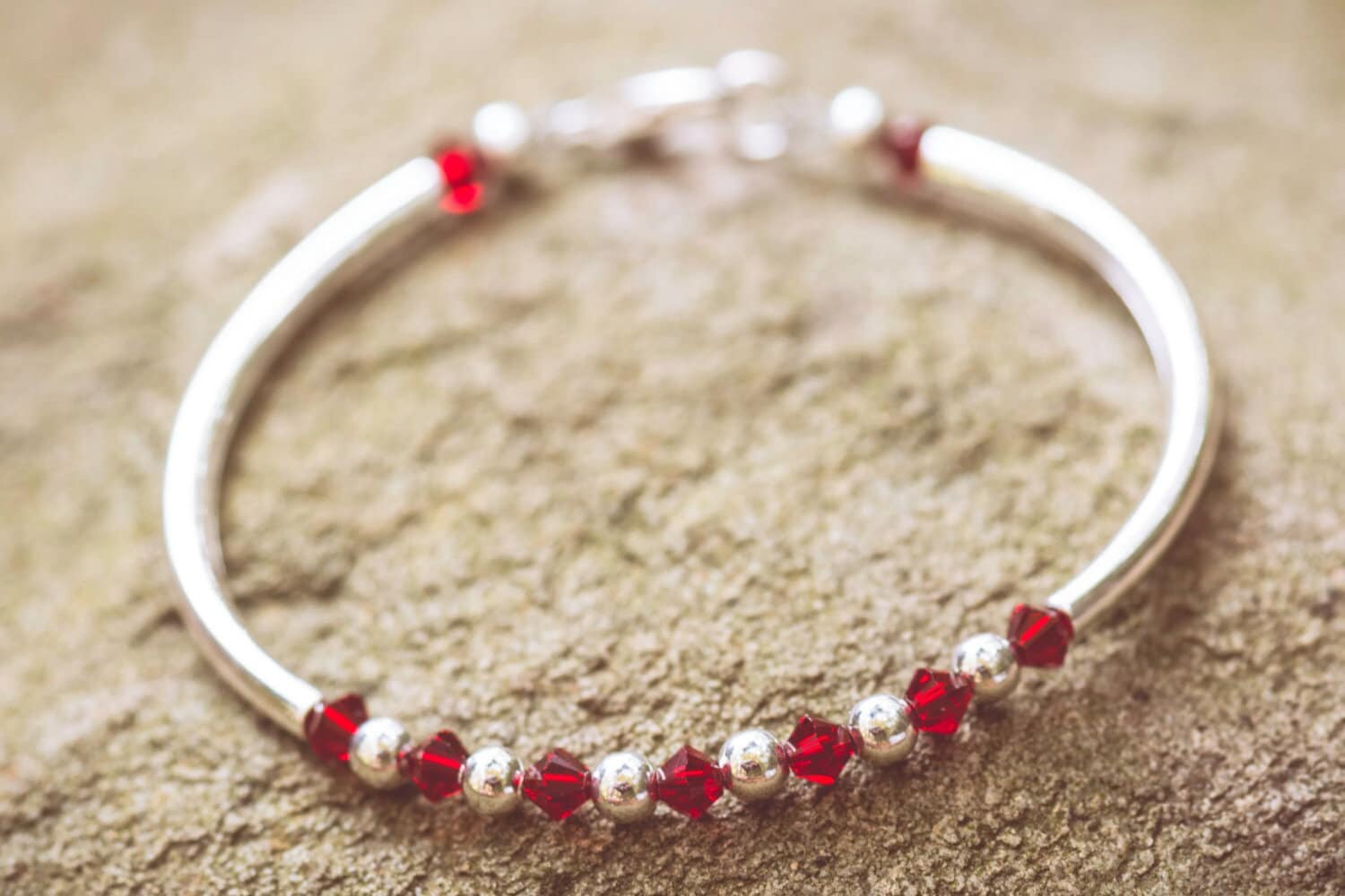 January Garnet Swarovski Crystal Birth Month Sterling Silver Plated Bracelet on stone